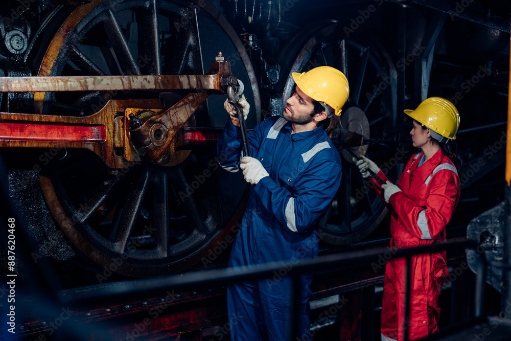 Fototapeta premium Team of engineer railway wearing safety uniform and helmet under checking under train ,wheels and control system for safety travel passenger. Maintenance cycle concept.