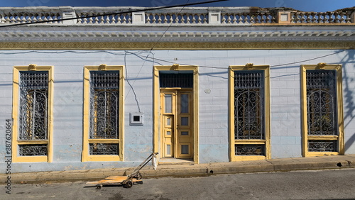 One-storey Eclectic house of grayish pale-blue facade, yellow moldings, gray and yellow door and windows, Calle Heredia Street. Santiago-Cuba-519 photo