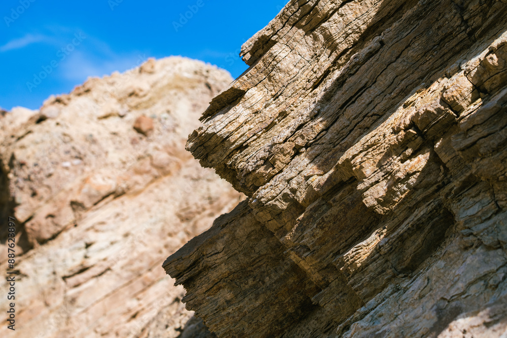 A rocky cliff with a blue sky in the background A rocky cliff with a blue sky in the background