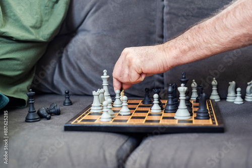 man's hand playing chess at home