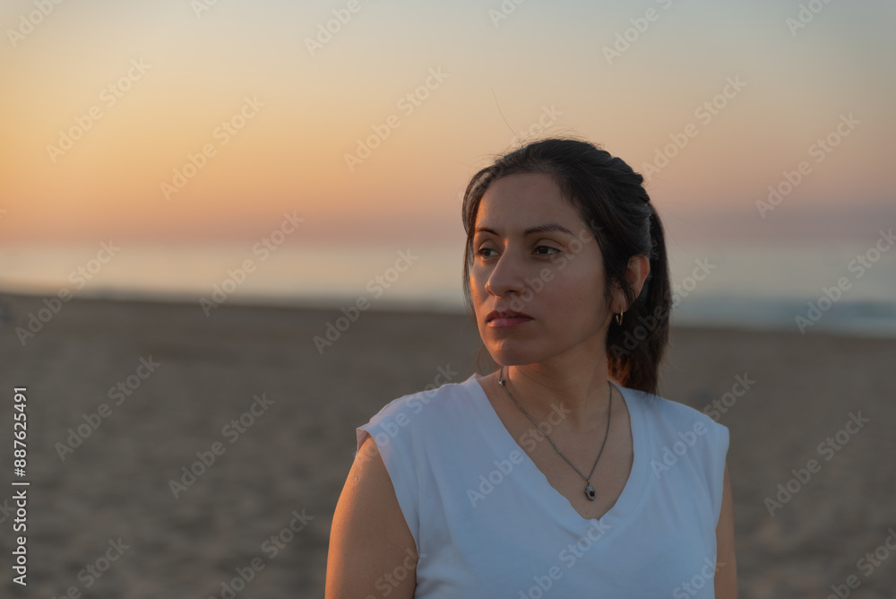 Woman contemplates the sunrise from the seashore. Woman contemplates the sunrise from the seashore.