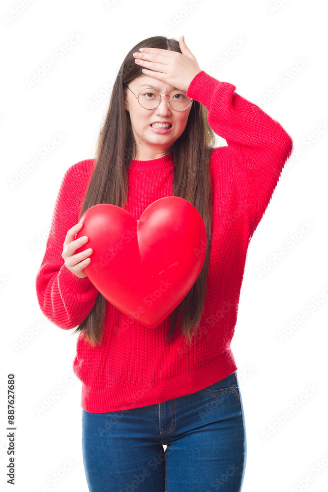 Young Chinese woman wearing graduate uniform red heart stressed with hand on head, shocked with shame and surprise face, angry and frustrated. Fear and upset for mistake. Young Chinese woman wearing graduate uniform red heart stressed with hand on head, shocked with shame and surprise face, angry and frustrated. Fear and upset for mistake.