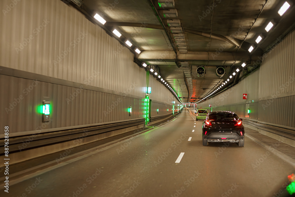 City road tunnel with cars on the road and artificial lighting. City road tunnel with cars on the road and artificial lighting.