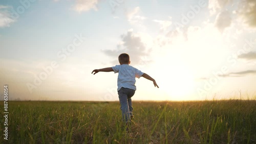 Happy child running. Imagination flying arms outstretched like pilot. play child dreams being pilot. Scenic outdoor adventure child playing freely. Future pilot fantasy child running imagining flight.