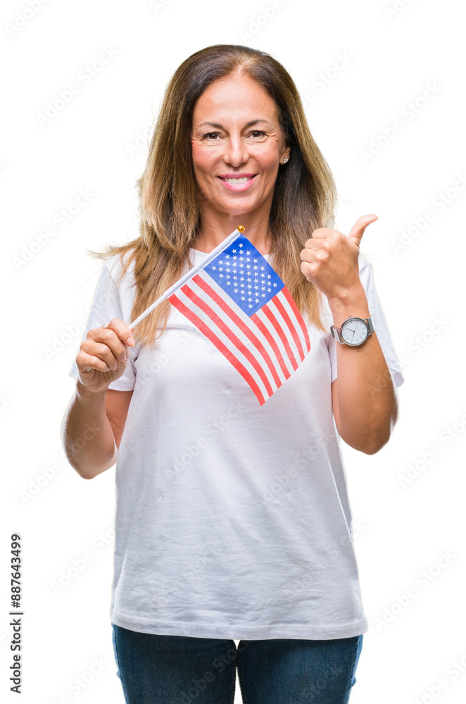 Middle age hispanic woman holding flag of United States of America over isolated background pointing and showing with thumb up to the side with happy face smiling Middle age hispanic woman holding flag of United States of America over isolated background pointing and showing with thumb up to the side with happy face smiling