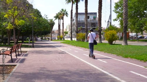 Young Man Riding Electric Scooter in City Bike Lane