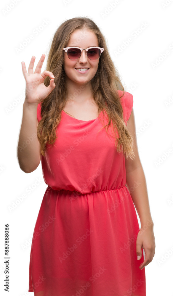 Young blonde woman wearing pink sunglasses doing ok sign with fingers, excellent symbol Young blonde woman wearing pink sunglasses doing ok sign with fingers, excellent symbol