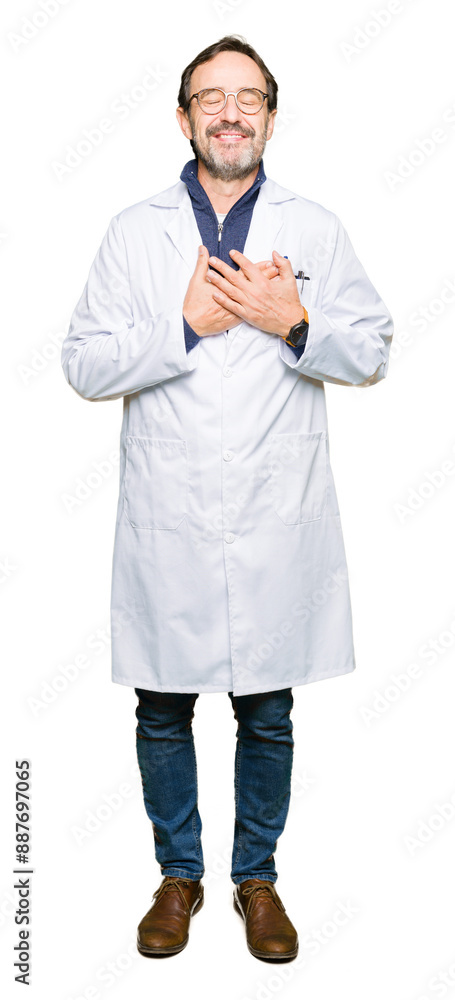 Middle age therapist wearing white coat smiling with hands on chest with closed eyes and grateful gesture on face. Health concept. Middle age therapist wearing white coat smiling with hands on chest with closed eyes and grateful gesture on face. Health concept.