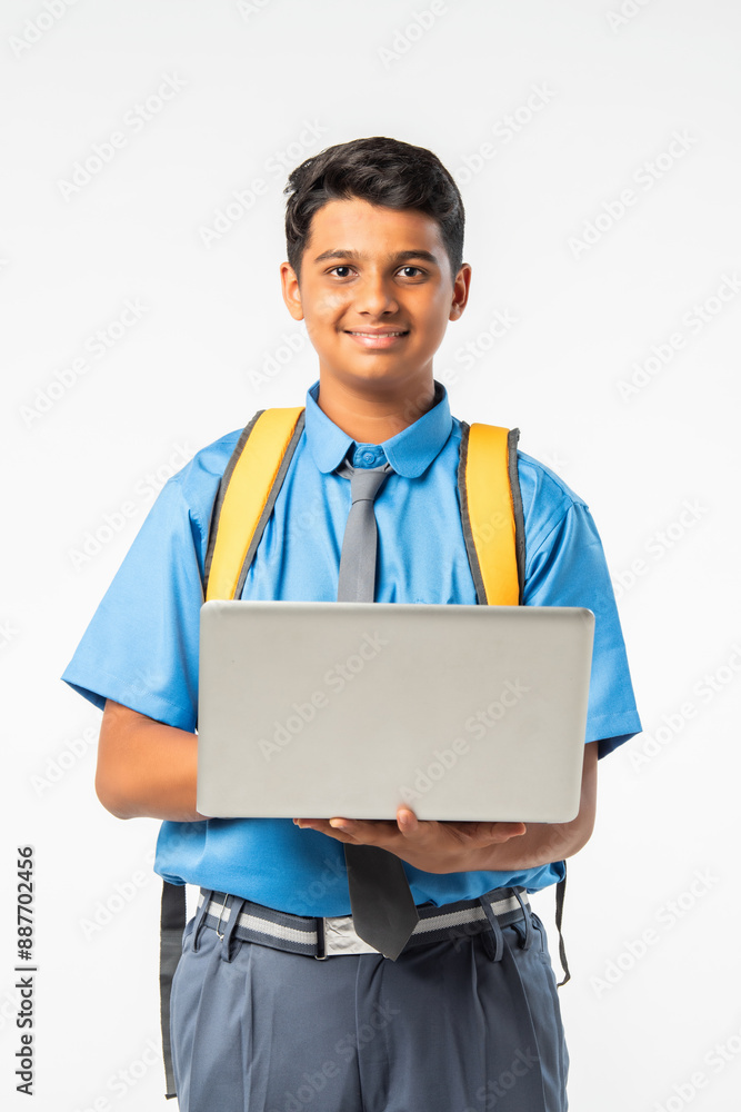 Indian Asian student in school uniform, holding laptop, isolated on white background, education concept Indian Asian student in school uniform, holding laptop, isolated on white background, education concept