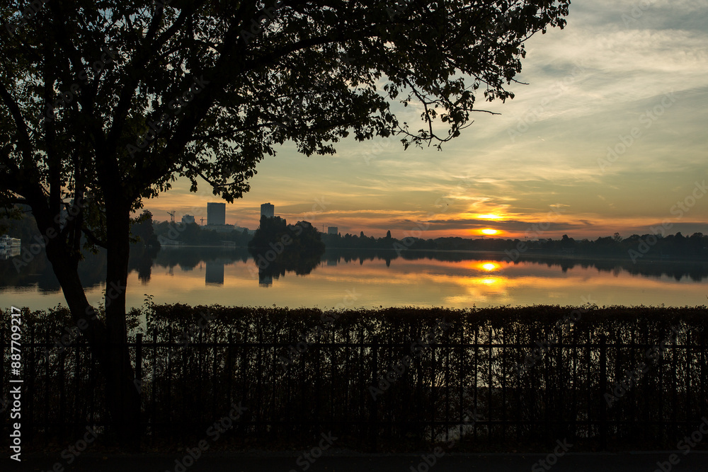 Park at sunrise with beautiful autumn colors and lake in background