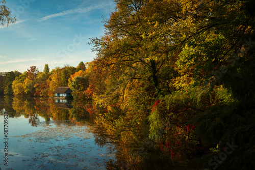 Landscape with beautiful house on a lake with colourful leafs in autumn season