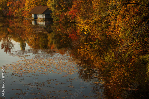 Obraz na płótnie Landscape with beautiful house on a lake with colourful leafs in autumn season w salonie