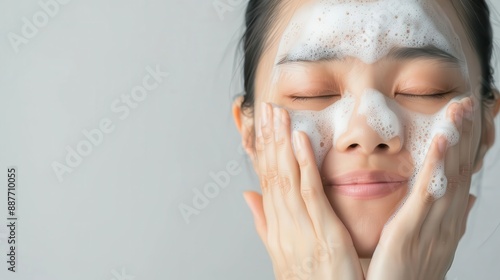 Asian woman washing her face with foam cleanser photo