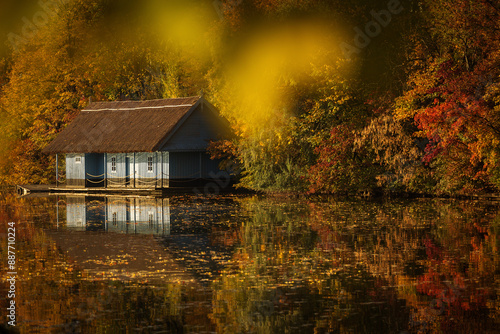 Landscape with beautiful house on a lake with colourful leafs in autumn season