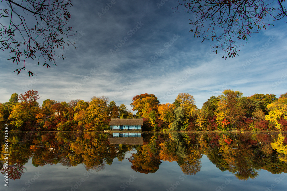 Landscape with beautiful house on a lake with colourful leafs in autumn season