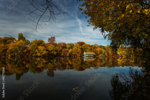 Landscape with beautiful house on a lake with colourful leafs in autumn season