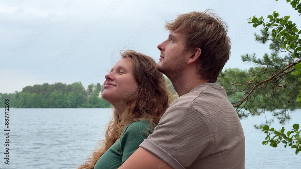 Happy young couple in love hugging and enjoy nature on lake at summer day