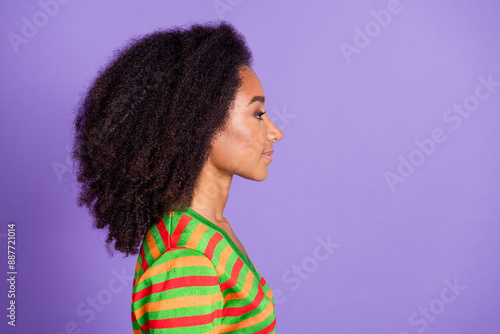 Photo of charming positive woman wear striped shirt looking empty space isolated violet color background photo