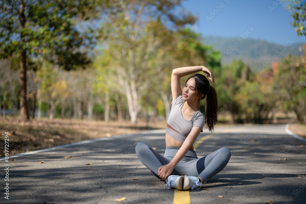 A woman is sitting on the road, stretching her arms and legs A woman is sitting on the road, stretching her arms and legs