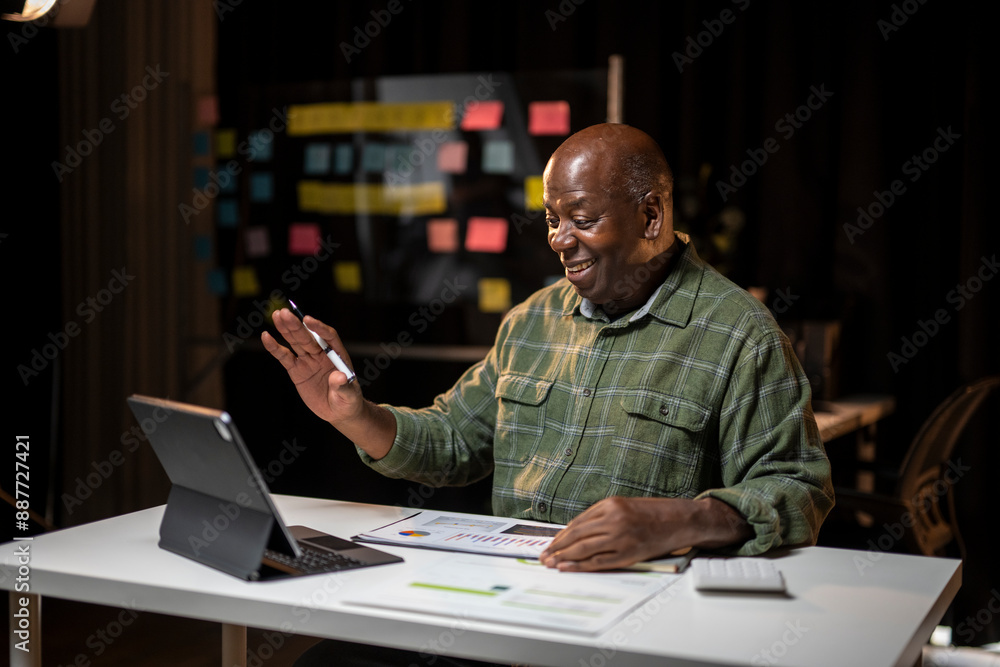 A man is sitting at a desk with a tablet in front of him A man is sitting at a desk with a tablet in front of him