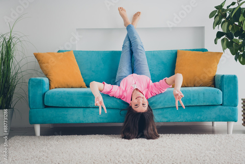 Photo of positive good mood woman dressed pink shirt smiling having fun showing v-signs indoors house apartment room