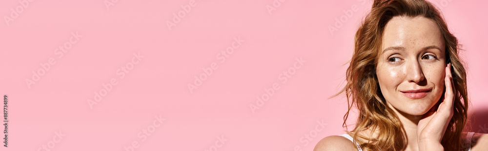A striking woman exudes elegance while posing gracefully in front of a vibrant pink background. A striking woman exudes elegance while posing gracefully in front of a vibrant pink background.