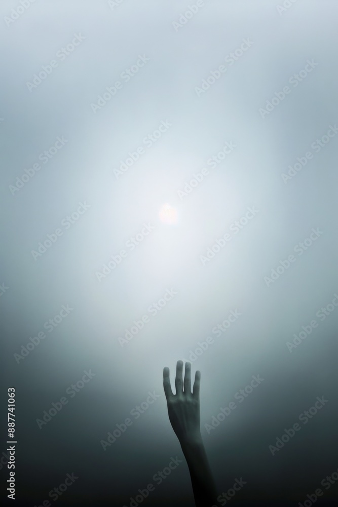 Silhouetted Hand Reaching Towards Misty Sunlight Through Fog