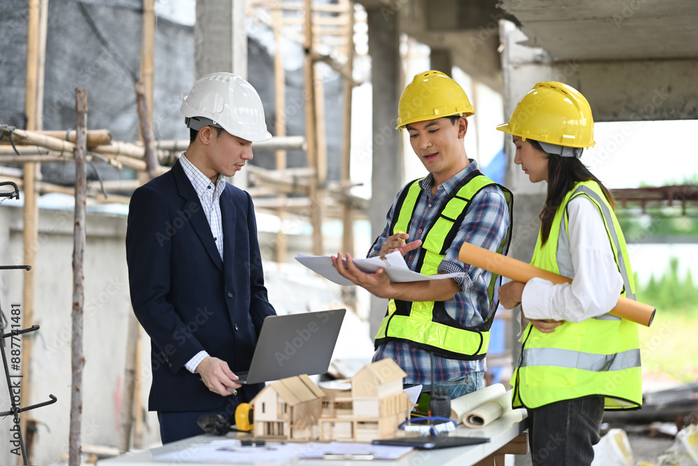 Male project manager and engineers discussing project details at building site Male project manager and engineers discussing project details at building site