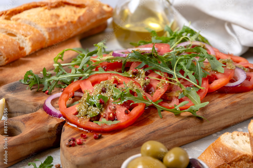 Organic tomato carpaccio with pesto sauce and arugula, an on-trend summer healthy eating salad Organic tomato carpaccio with pesto sauce and arugula, an on-trend summer healthy eating salad