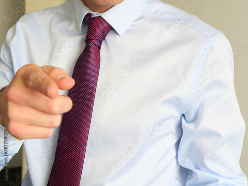 caucasian man in blue shirt with blue and red, purple tie. Professional and banker look. how to tie a perfect tie knot photo