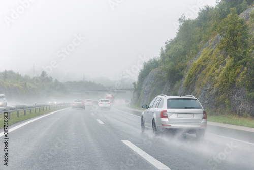 Back tail view of many cars driving fast on wet highway road after rain in Europe. Automobile accident vehicle rush hour collapse. Transportation vacation seasonal stuck