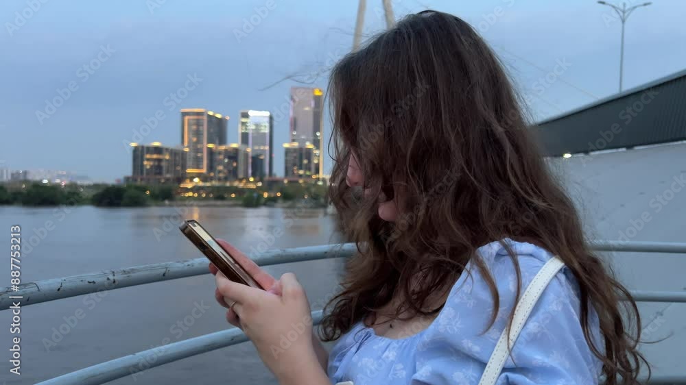 when i am a girl tourist walking with a phone along the embankment in vietnam in ho chi minh new district when i am a girl tourist walking with a phone along the embankment in vietnam in ho chi minh new district