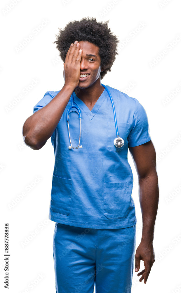 Afro american surgeon doctor man over isolated background covering one eye with hand with confident smile on face and surprise emotion. Afro american surgeon doctor man over isolated background covering one eye with hand with confident smile on face and surprise emotion.