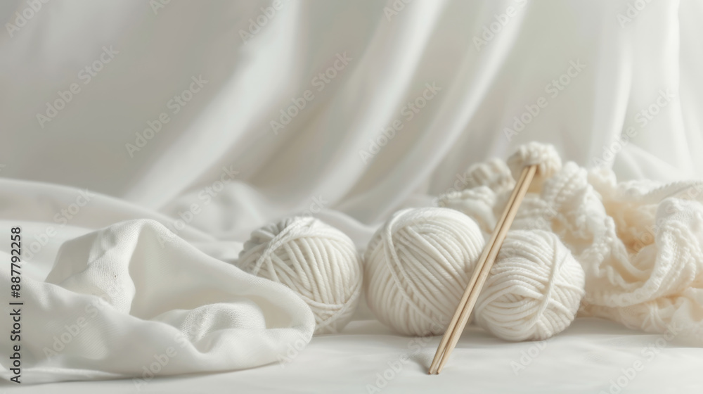 Obraz premium Soft Knitting Setup with White Yarn and Wooden Needles