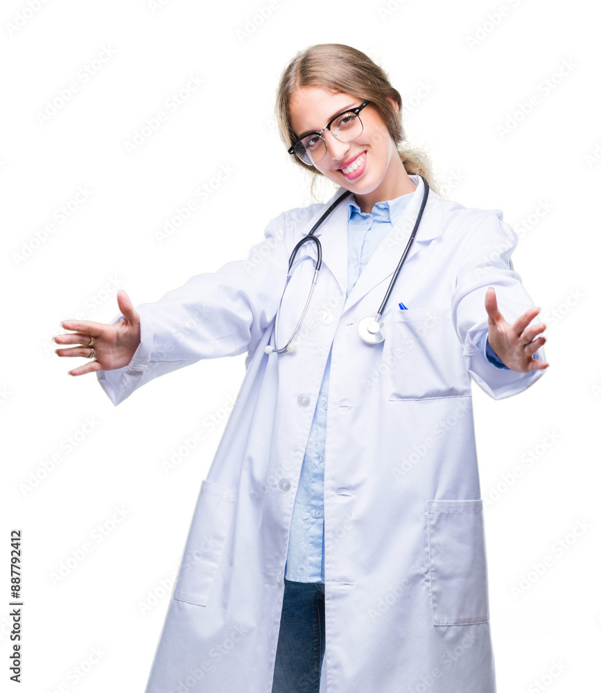 Beautiful young blonde doctor woman wearing medical uniform over isolated background looking at the camera smiling with open arms for hug. Cheerful expression embracing happiness. Beautiful young blonde doctor woman wearing medical uniform over isolated background looking at the camera smiling with open arms for hug. Cheerful expression embracing happiness.