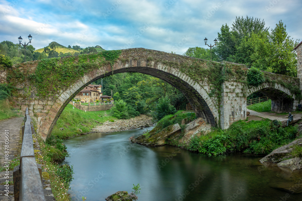 Medieval semicircular arch bridge over the Miera river, Liérganes, Cantabria, Spain, seen from the side Medieval semicircular arch bridge over the Miera river, Liérganes, Cantabria, Spain, seen from the side