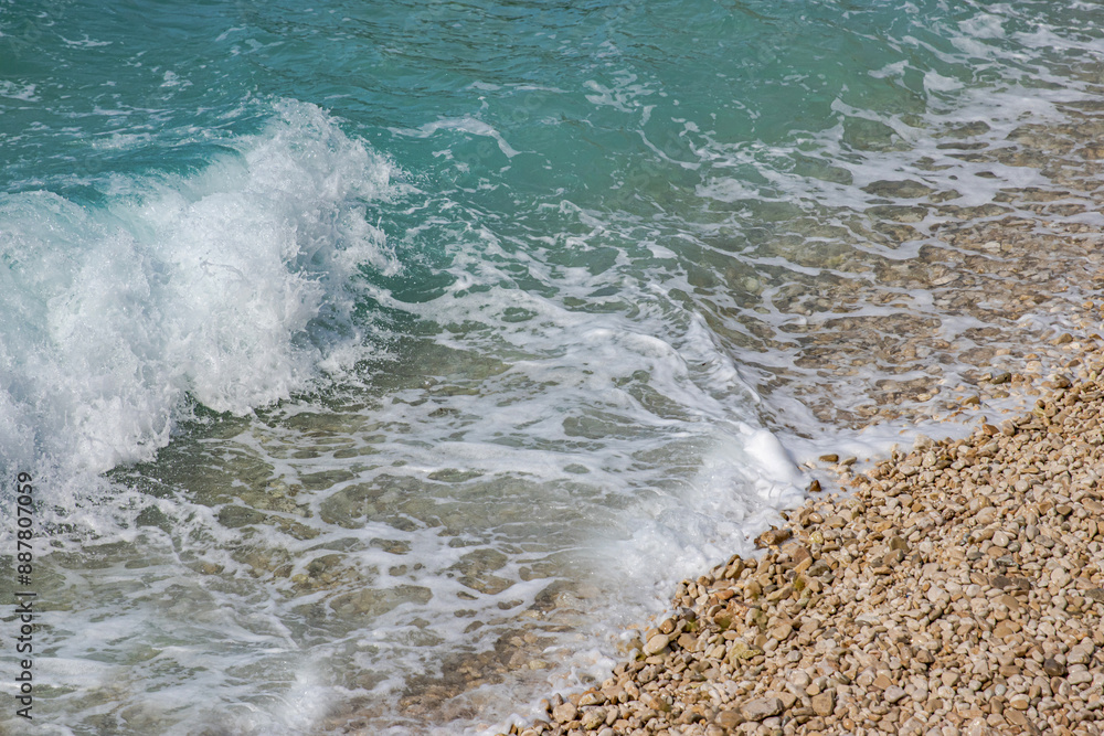Beautiful pebbles beach with waves and blue sky. Relaxing aerial scene, summer vacation. Holiday template banner. Waves surf with amazing blue ocean lagoon, sea shore, coastline. Copy space. Beautiful pebbles beach with waves and blue sky. Relaxing aerial scene, summer vacation. Holiday template banner. Waves surf with amazing blue ocean lagoon, sea shore, coastline. Copy space.