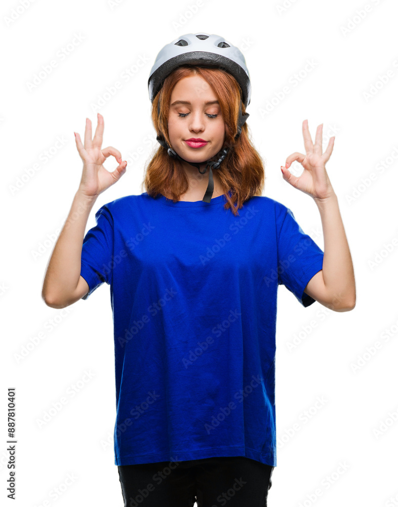 Young beautiful woman wearing cyclist helmet over isolated background relax and smiling with eyes closed doing meditation gesture with fingers. Yoga concept. Young beautiful woman wearing cyclist helmet over isolated background relax and smiling with eyes closed doing meditation gesture with fingers. Yoga concept.