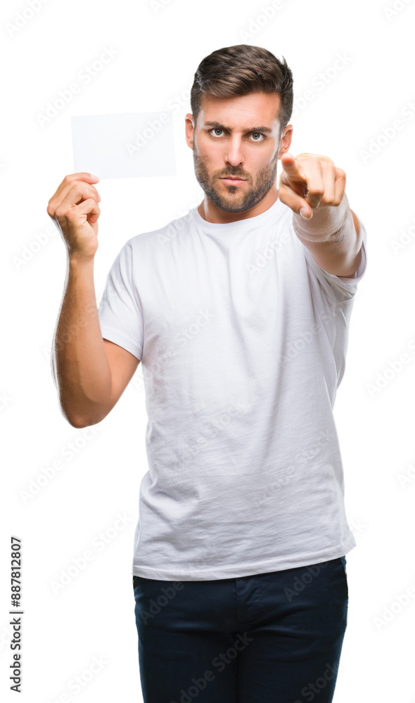 Fototapeta premium Young handsome man holding blank card over isolated background pointing with finger to the camera and to you, hand sign, positive and confident gesture from the front