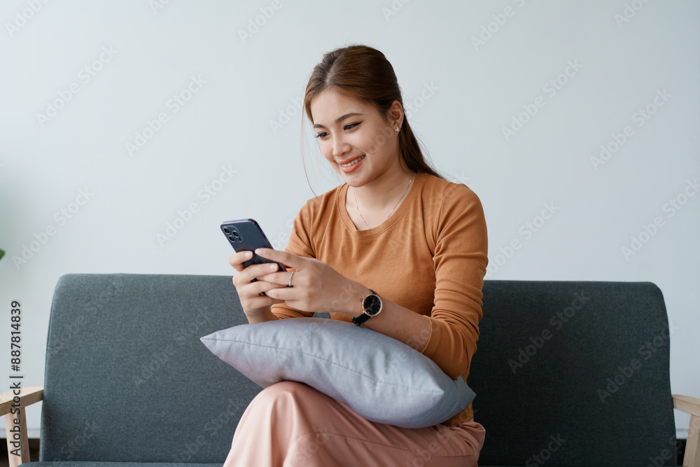 Obraz premium woman relaxation on a sofa, scrolling through social media on her smartphone