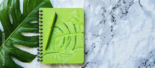 A green notebook and pen on...