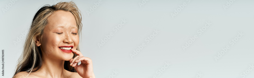 An attractive Asian woman smiles while posing. An attractive Asian woman smiles while posing.
