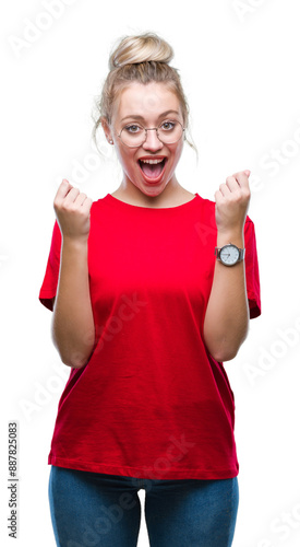 Young blonde woman wearing glasses over isolated background celebrating surprised and amazed for success with arms raised and open eyes. Winner concept.