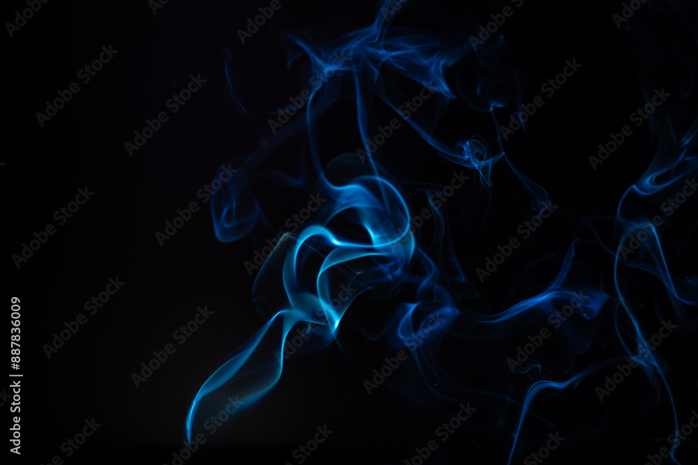 Obraz premium Blue smoke isolated on a black background. A thin curved line of smoke, steam from a burnt candle to overlay on your photos