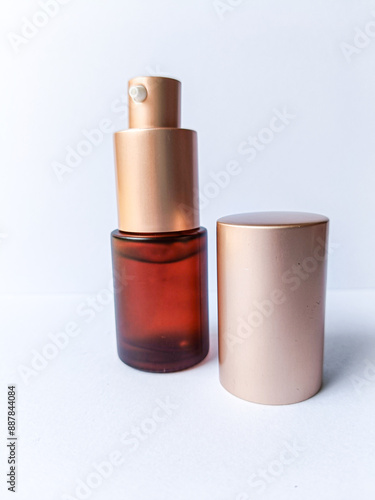 brown gold cosmetic glass pump bottle on isolated white background