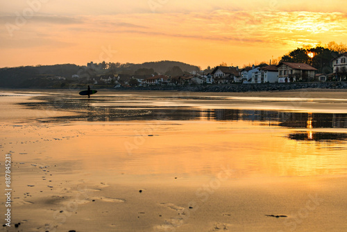 Surfer on the shore of the beach at dawn