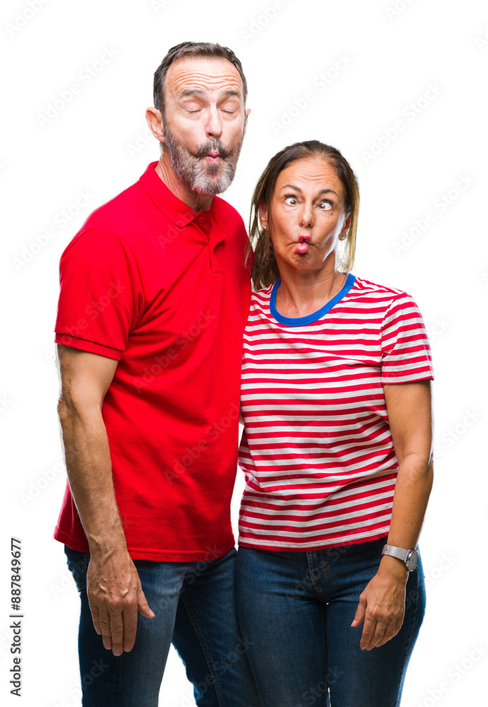 Fototapeta premium Middle age hispanic couple in love over isolated background making fish face with lips, crazy and comical gesture. Funny expression.