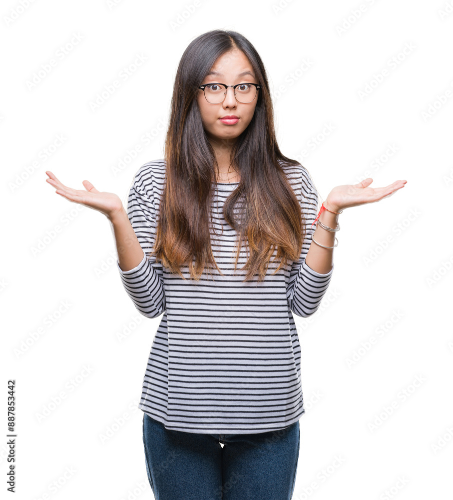 Young asian woman wearing glasses over isolated background clueless and confused expression with arms and hands raised. Doubt concept. Young asian woman wearing glasses over isolated background clueless and confused expression with arms and hands raised. Doubt concept.