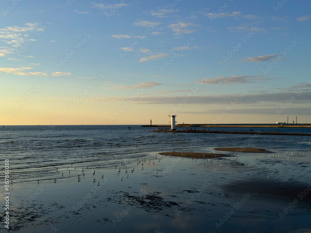 Sunset over the harbor. Lighthouse on the breakwater Sunset over the harbor. Lighthouse on the breakwater