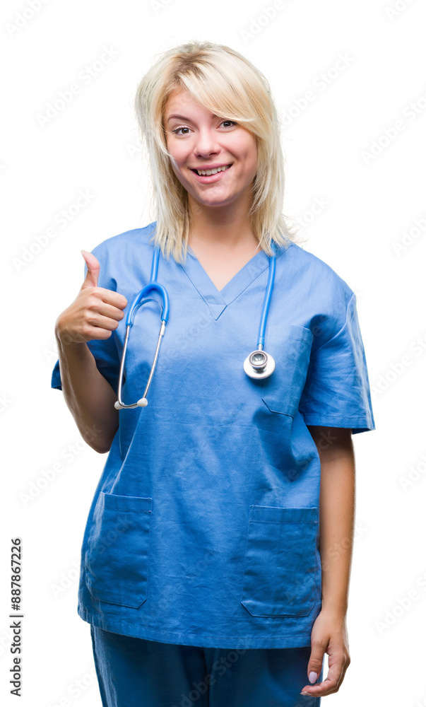 Young beautiful blonde doctor woman wearing medical uniform over isolated background doing happy thumbs up gesture with hand. Approving expression looking at the camera with showing success. Young beautiful blonde doctor woman wearing medical uniform over isolated background doing happy thumbs up gesture with hand. Approving expression looking at the camera with showing success.